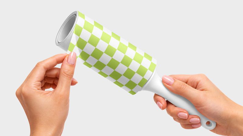 Lint roller mockup with a white handle and a lime green and white checkerboard wrapper held in two hands