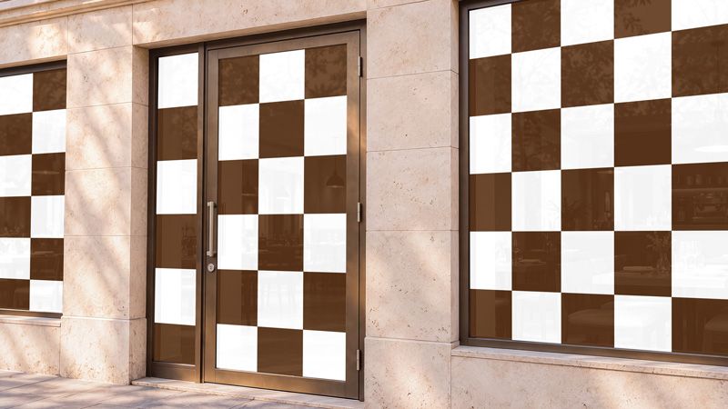 Restaurant window mockup with brown and white checkerboard artwork across the storefront windows and glass entrance door