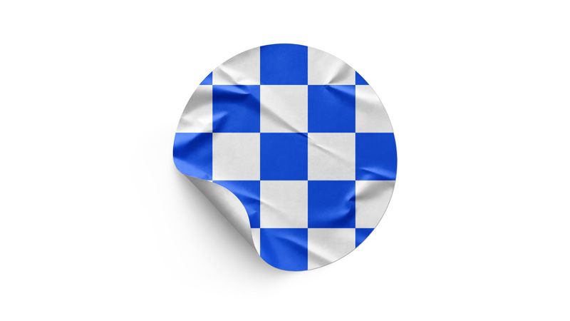 Wrinkled round sticker mockup with a blue and white checkerboard design and curled edge on a white background